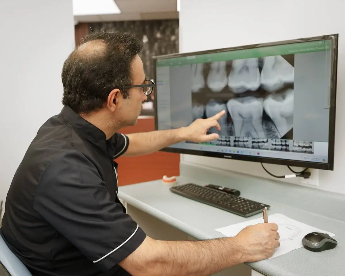 Dentist showing x-ray on monitor in modern dental clinic.jpg