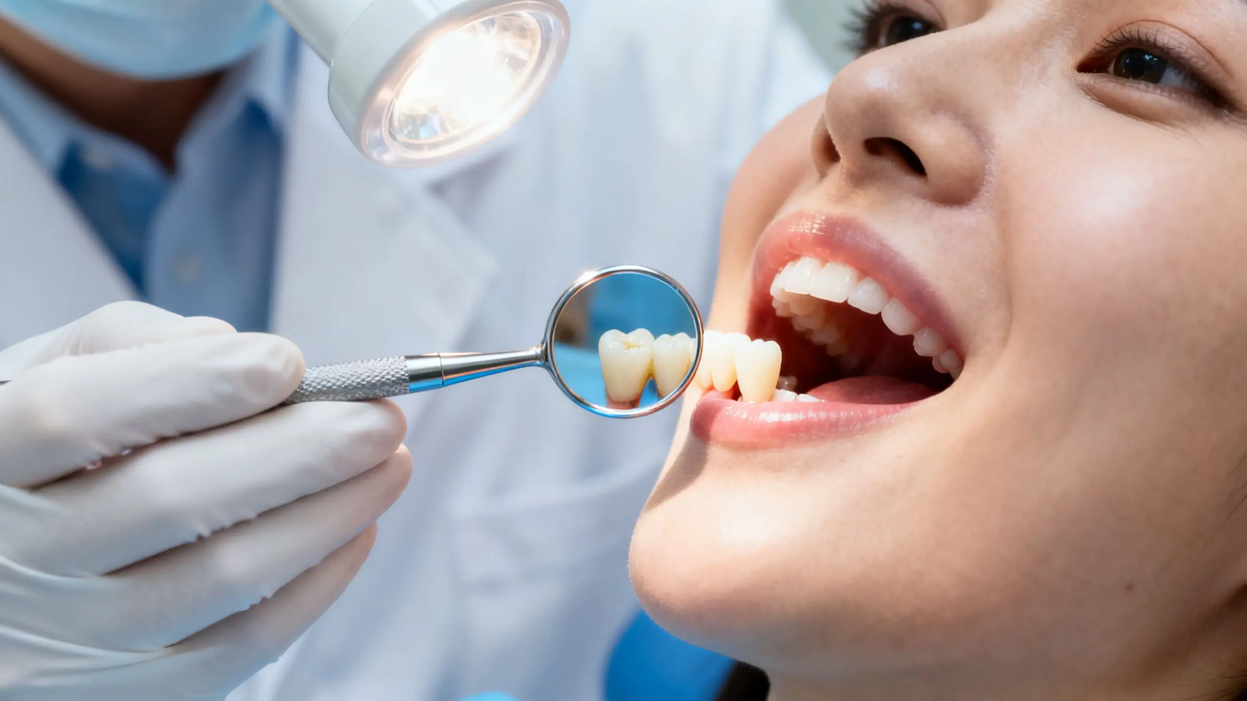 A close-up, clinical-style photo showing a dentist examining a patient's tooth with a dental mirror, conveying a sense of professional care and diagnosis for a root canal.