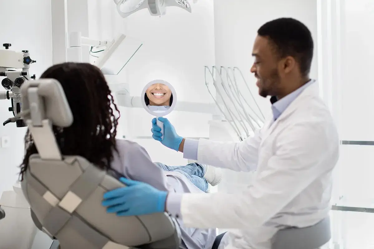 Dentist showing patient their smile in mirror during consultation