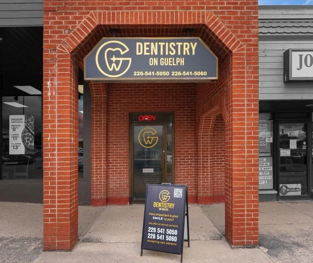 The entrance to Dentistry on Guelph on Eramosa Road, with the clinic sign above the door and a sidewalk sign out front