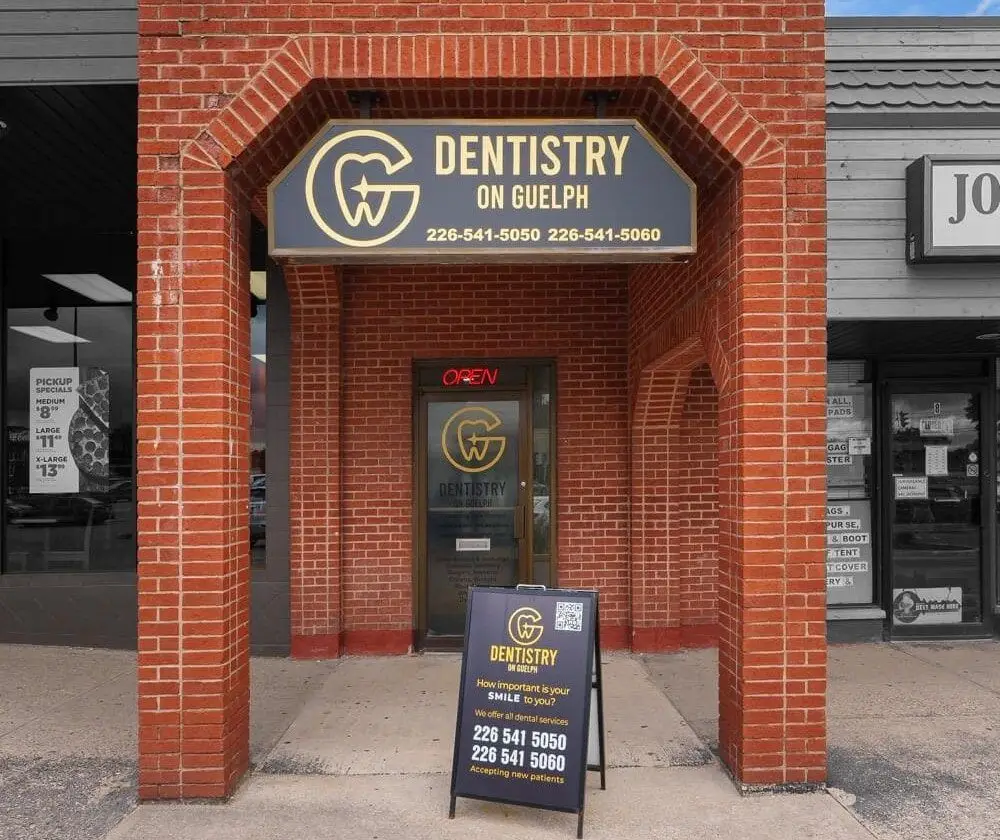 The entrance to Dentistry on Guelph on Eramosa Road, with the clinic sign above the door and a sidewalk sign out front